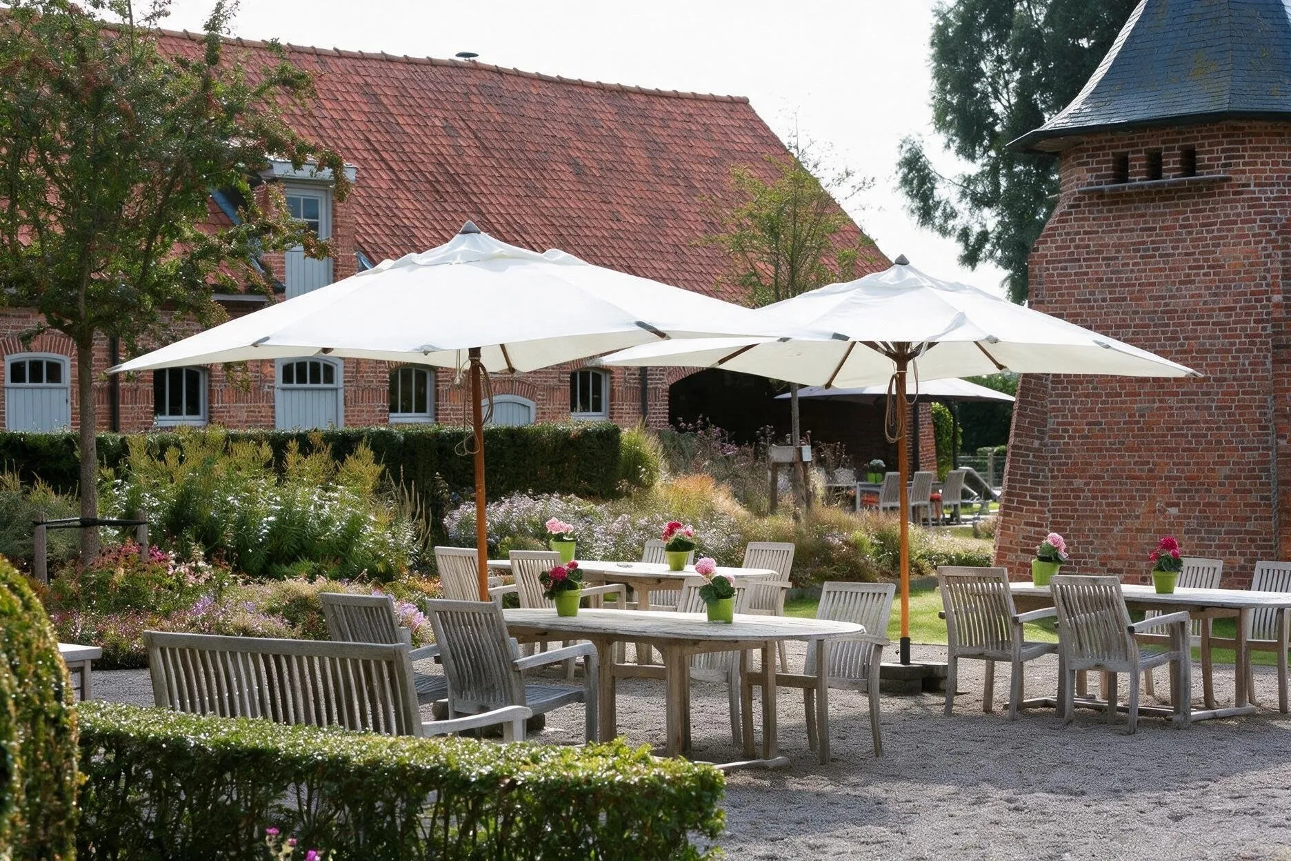 Terras met parasols bij de historische hoeve en duiventil